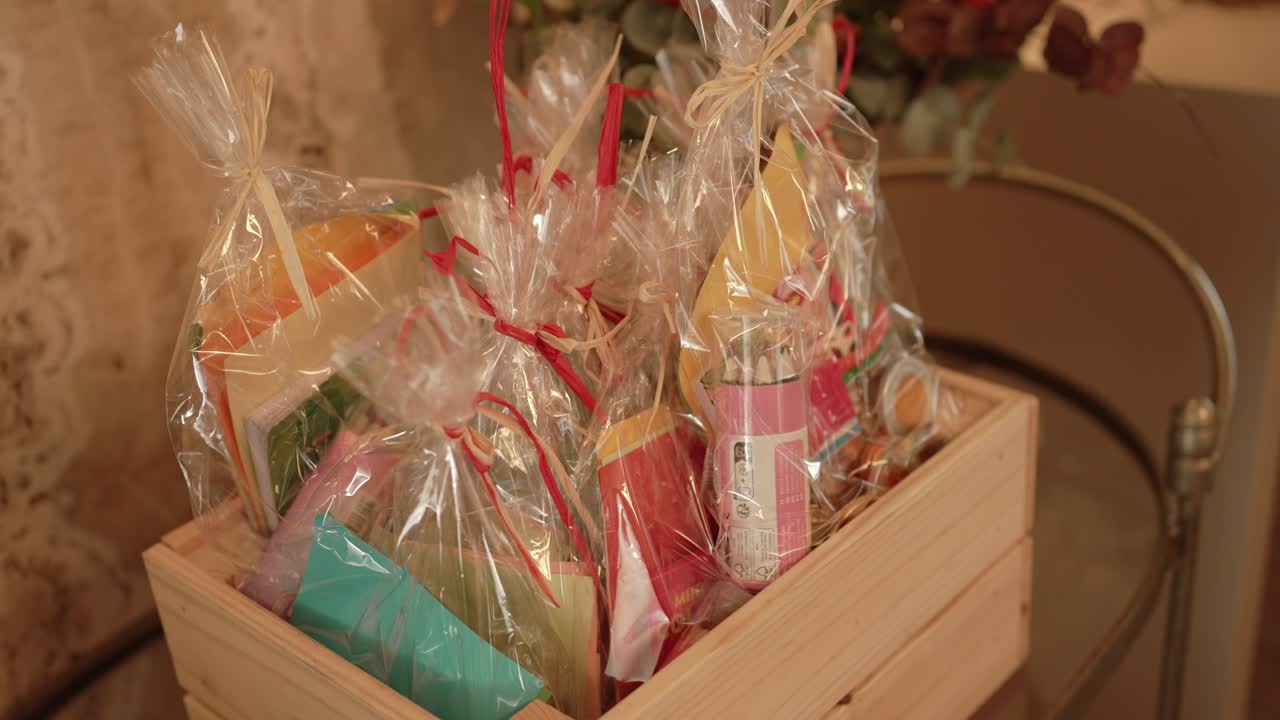 Assorted wedding favors wrapped in cellophane inside wooden crate location irrelevant