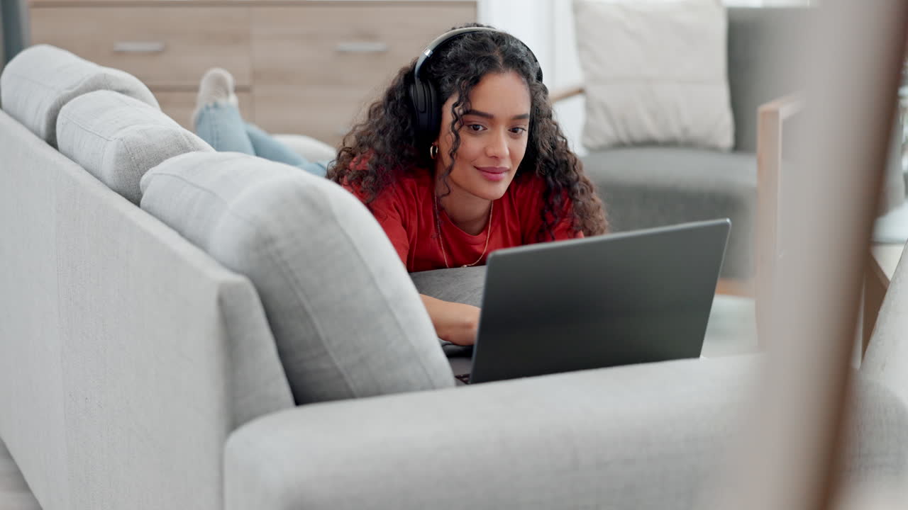 Woman lying on sofa with laptop