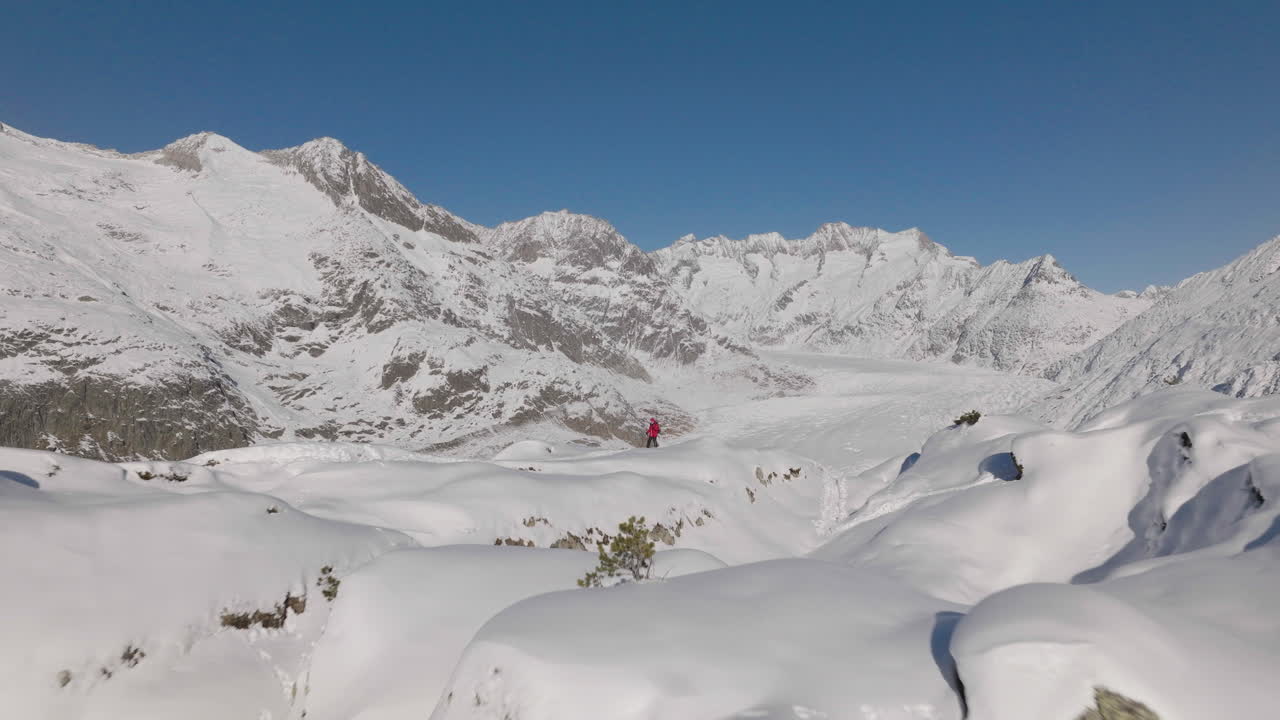 뒤에 빙하와 함께 화창한 날에 눈 신발을 신고 걷는 사람과 스위스에서 공중 촬영
