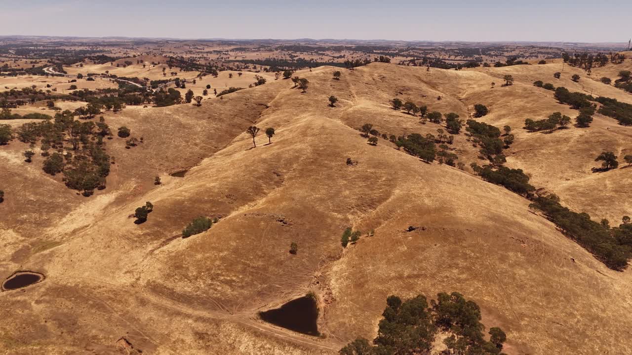 Wagga Hill, crinali a strati e valli aride che si estendono attraverso la campagna in una luce calda, NSW Australia, orbita aerea