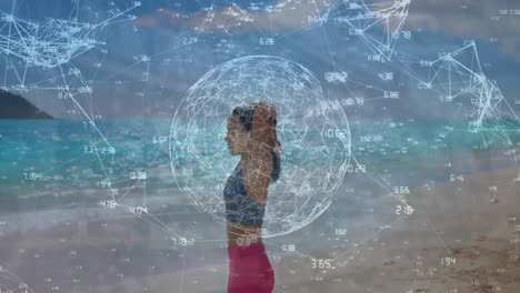 Animation-of-digital-globe-and-numbers-over-young-woman-practicing-yoga-at-beach-against-sky