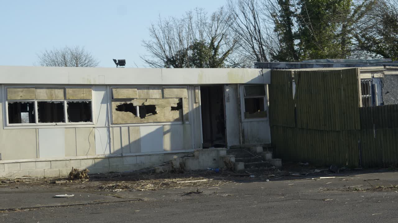 Abandoned Disused Building with Boarded Up Windows with Smashed Hole and Missing Doors and Broken Windows. Post Apocalyptic Setting.