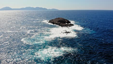 white foamy waves splashing on huge rocks in jerusalem beach, erisos, greece - aerial drone shot