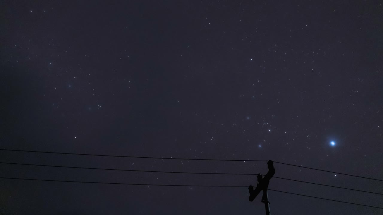Cloudy night sky timelapse Sirius bright start moving over skyline timelapse, electric pole in the foreground