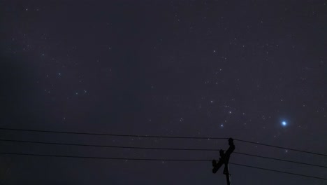 cloudy night sky timelapse sirius bright start moving over skyline timelapse, electric pole in the foreground