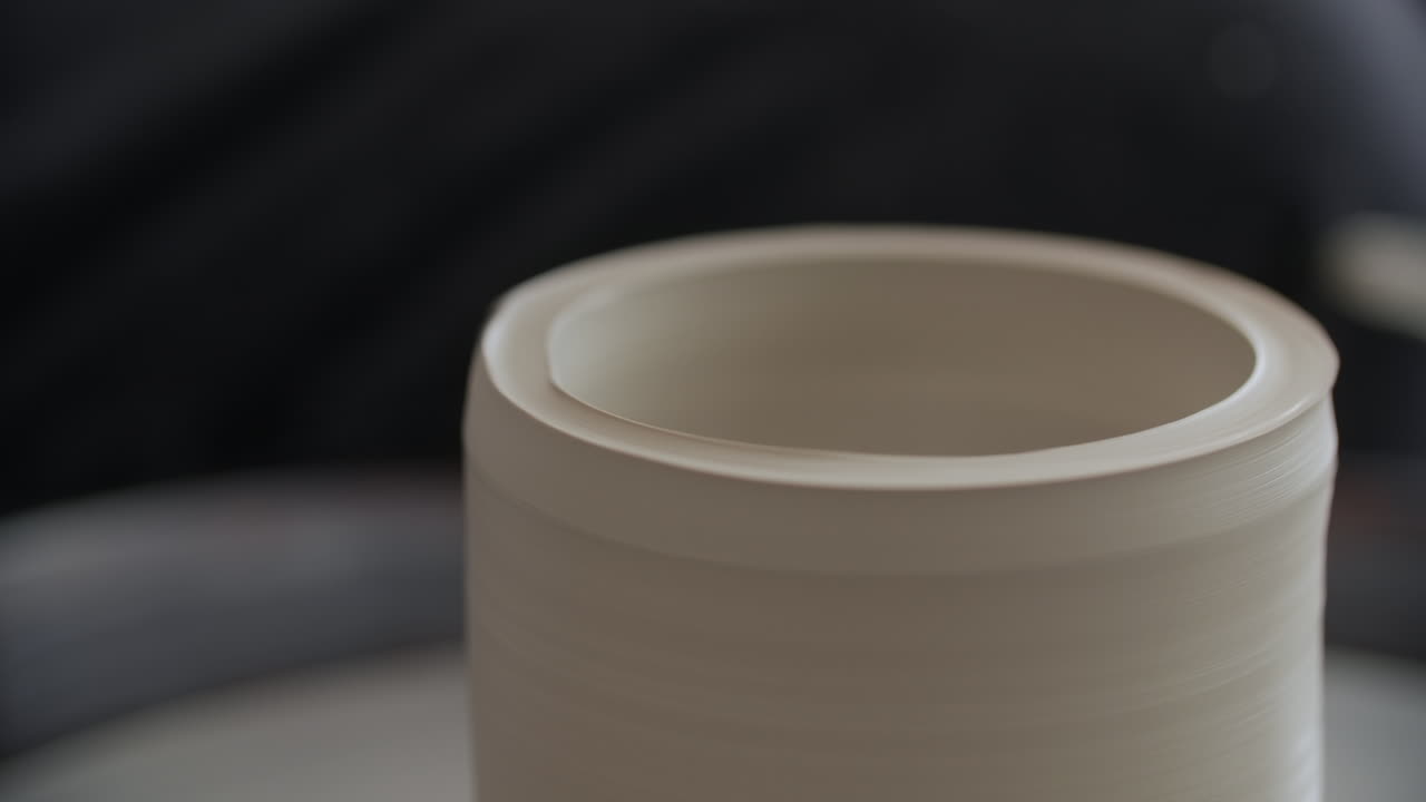 primer plano de un alfarero moldeando arcilla en una rueda de cerámica