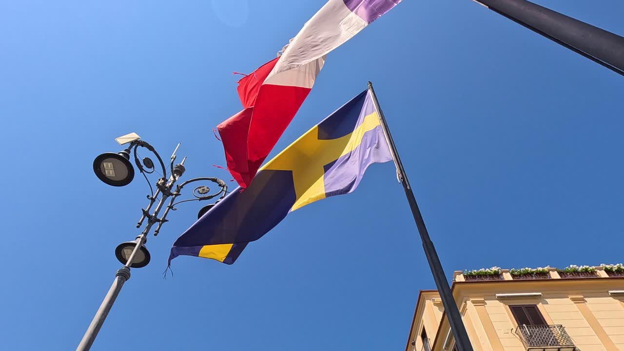 Flags fluttering against a clear blue sky