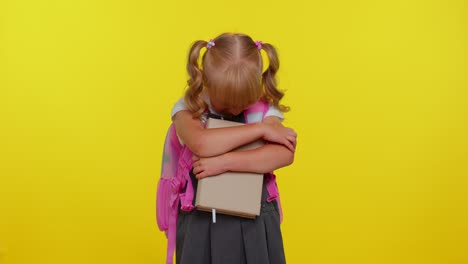 upset disappointed blond teenage schoolgirl kid with book wipes tears and cries from despair