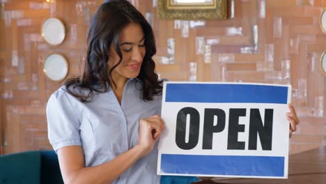 hermosa mujer sosteniendo un cartel abierto