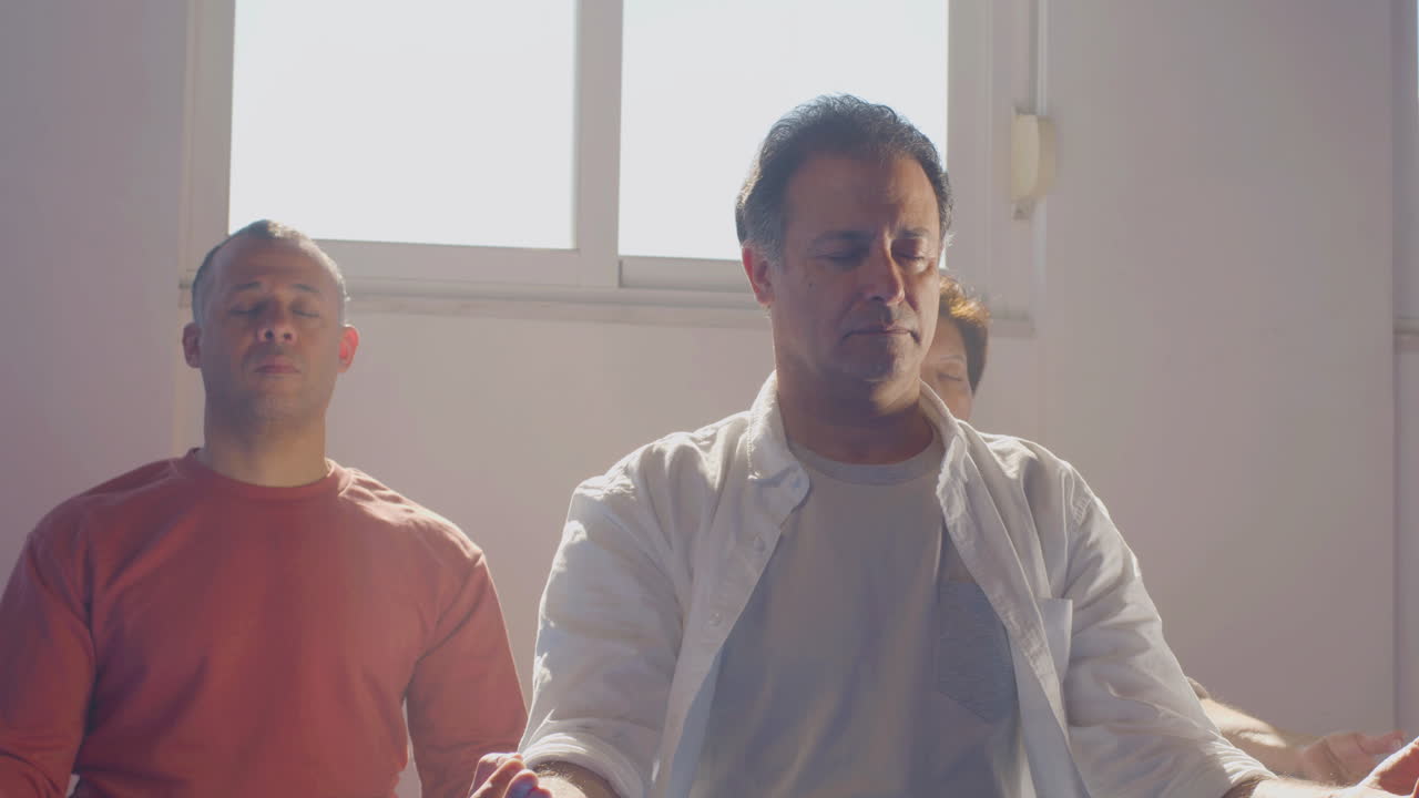 눈을 감고 로터스 자세로 앉아 명상하는 사람들