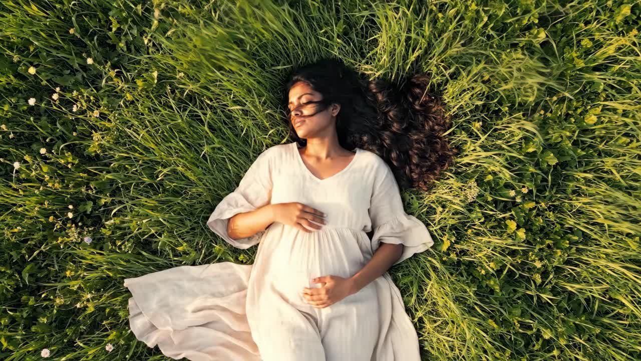 Pregnant woman lying in a grassy field