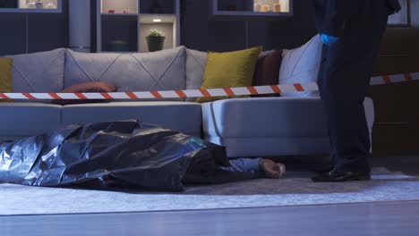 la policía está examinando el cuerpo en la escena del crimen.