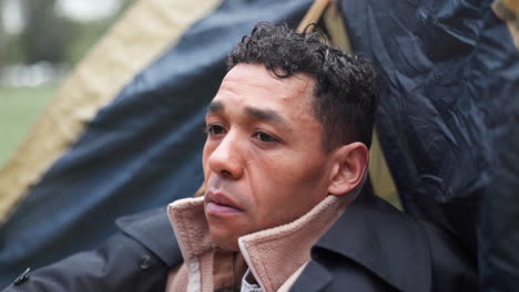 man sitting outdoors near tent