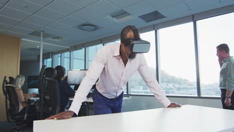 African American businessman wearing VR headset in modern office