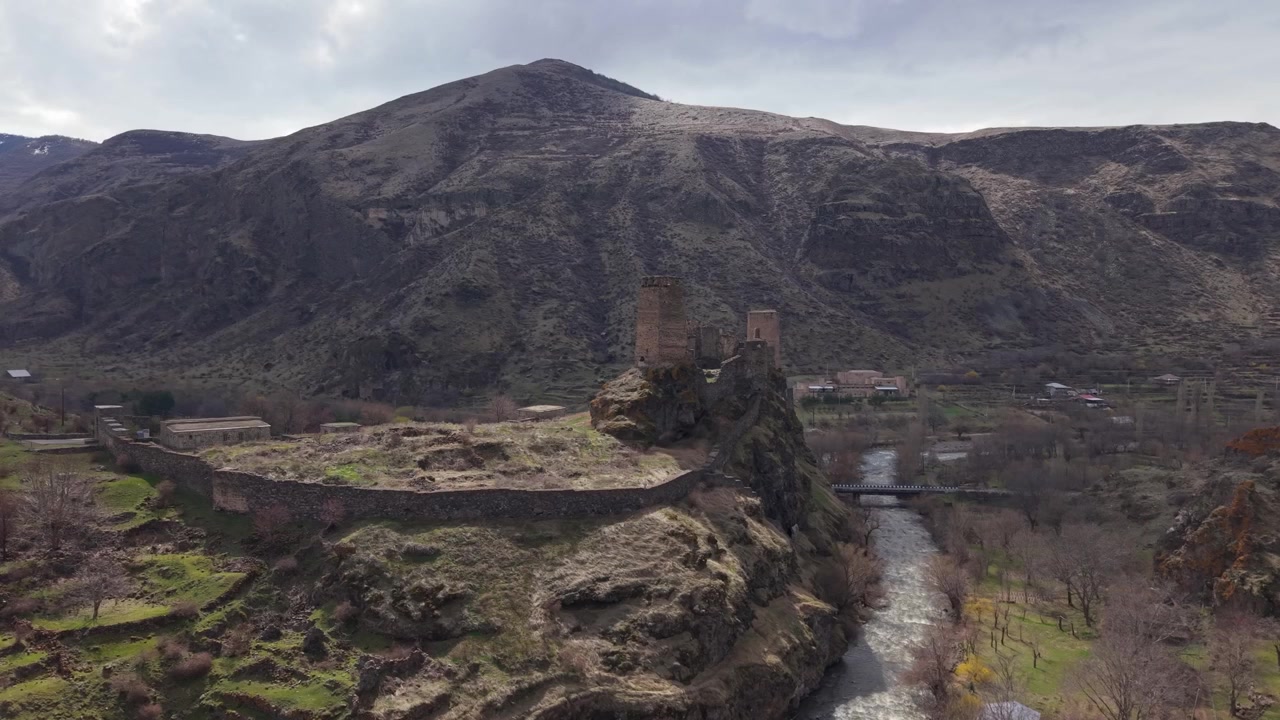 Riprese drone della Fortezza di Khertvisi con il fiume che scorre accanto, circondata da un pittoresco paesaggio montano e uno storico scenario georgiano.