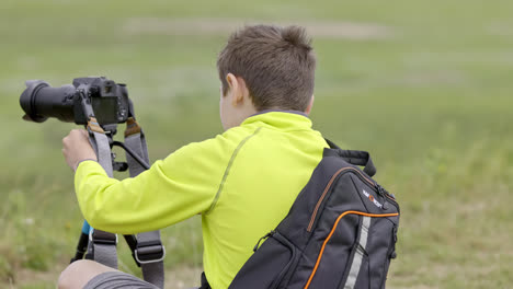 Young-boy,-photographer-setting-up-his-tripod-for-wildlife-video-production