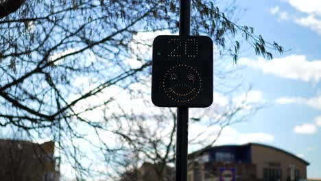 Señal-De-Velocidad-De-Radar-En-El-Reino-Unido,-Veinte-Millas-Por-Hora,-Cara-Sonriente-Feliz-Mientras-Los-Automóviles-Y-Los-Usuarios-De-La-Carretera-Respetan-El-Límite-De-Velocidad,-En-Un-Día-Soleado