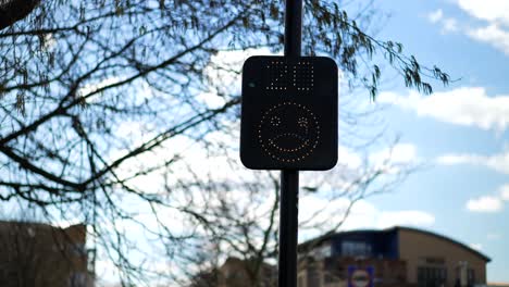 señal de velocidad de radar en el reino unido, veinte millas por hora, cara sonriente feliz mientras los automóviles y los usuarios de la carretera respetan el límite de velocidad, en un día soleado