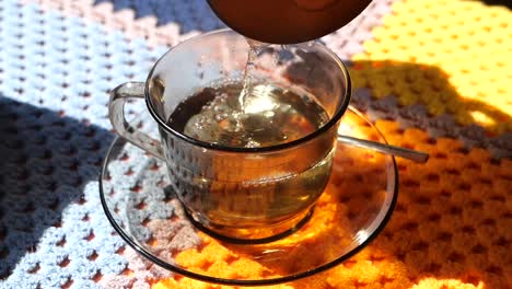 pouring tea into a glass cup