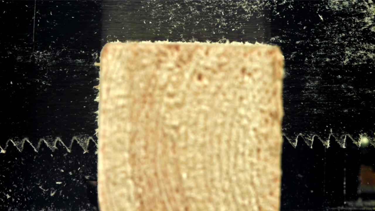 Saw Blade Cutting Through Wood with Flying Sawdust