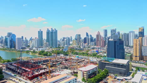 time-lapse of queen sirikit national convention centre construction site near benjakitti park and lake, millenium residence apartment, cti tower, ocean tower in bangkok, cloudscape on a sunny day