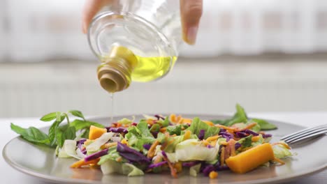 Pouring-olive-oil-on-the-salad.-Eating-healthy.