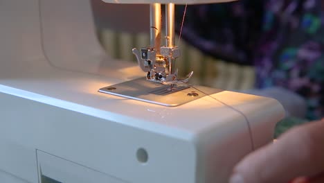 close up on tailor hands thread, preparing sewing machine for work