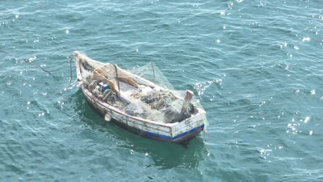 fishing boat anchored peacefully in calm blue water in sunny day , lima, peru