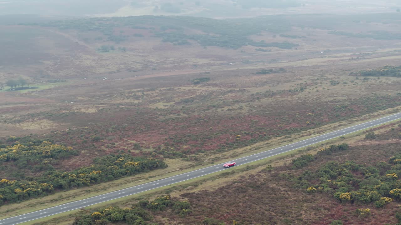 toma aérea de drones rastreando auto en carretera abierta
