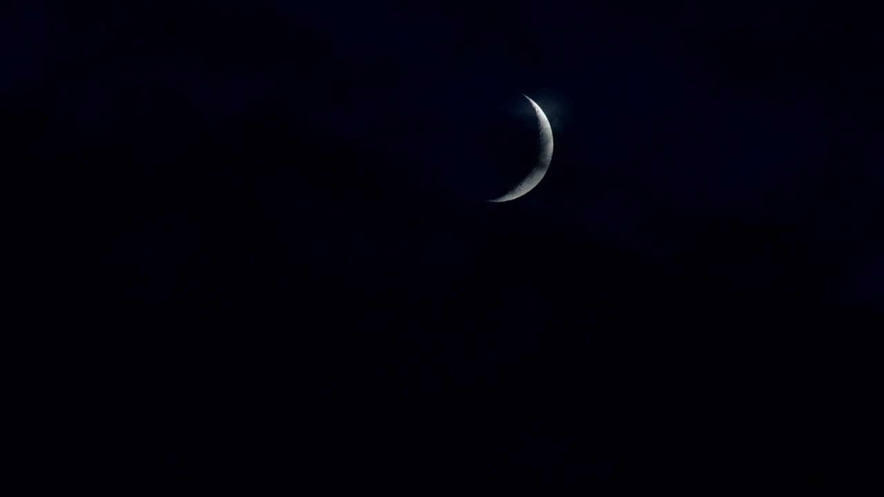 Crescent Moon With Clouds That Are Blown By The Wind During A Storm At Night Clouds Float Past The Moon. On The Surface, You Can See Details Of The Moon