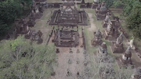aerial view towards and over wat chedi chet thaeo at si satchanalai historical park at sukhothai, thailand.