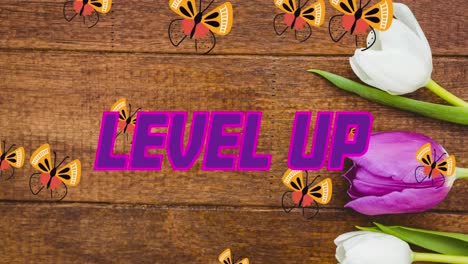 Animation-of-pink-and-purple-text-level-up,-with-butterflies-and-tulips-on-wood
