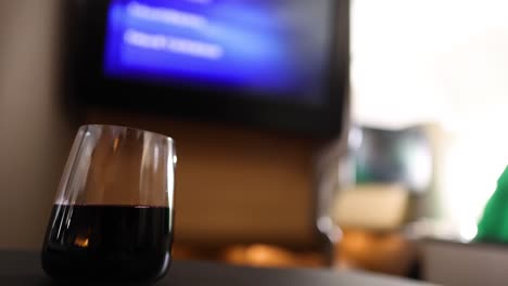 individual sips drink while watching in-flight entertainment