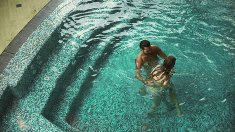 Pareja-Joven-Bañándose-Juntos.-Pareja-Sexy-Coqueteando-En-El-Spa-De-La-Piscina.