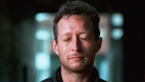 man gets splashed with water, droplets bouncing off, and he closes his eyes in motion