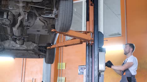 a mechanic working in an auto service shop with a car on a hydraulic lift