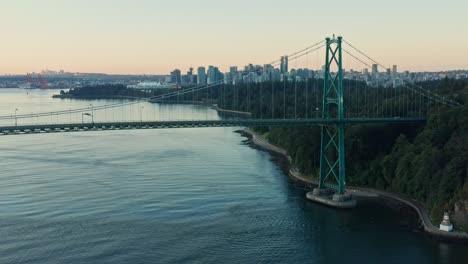 dolly drone aerial shot at lions gate bridge moving side the side as car is passing by during sunset