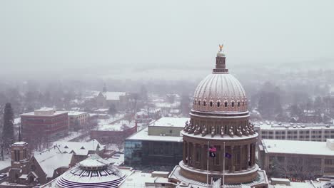 orbiting aerial of the capital building in boise, idaho with a layer of snow on it