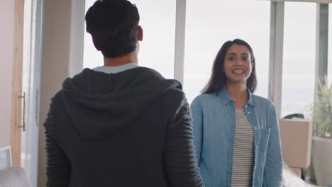 pareja joven mudándose de casa nuevos dueños de casa sonriendo disfrutando de una mudanza exitosa abrazándose en el apartamento