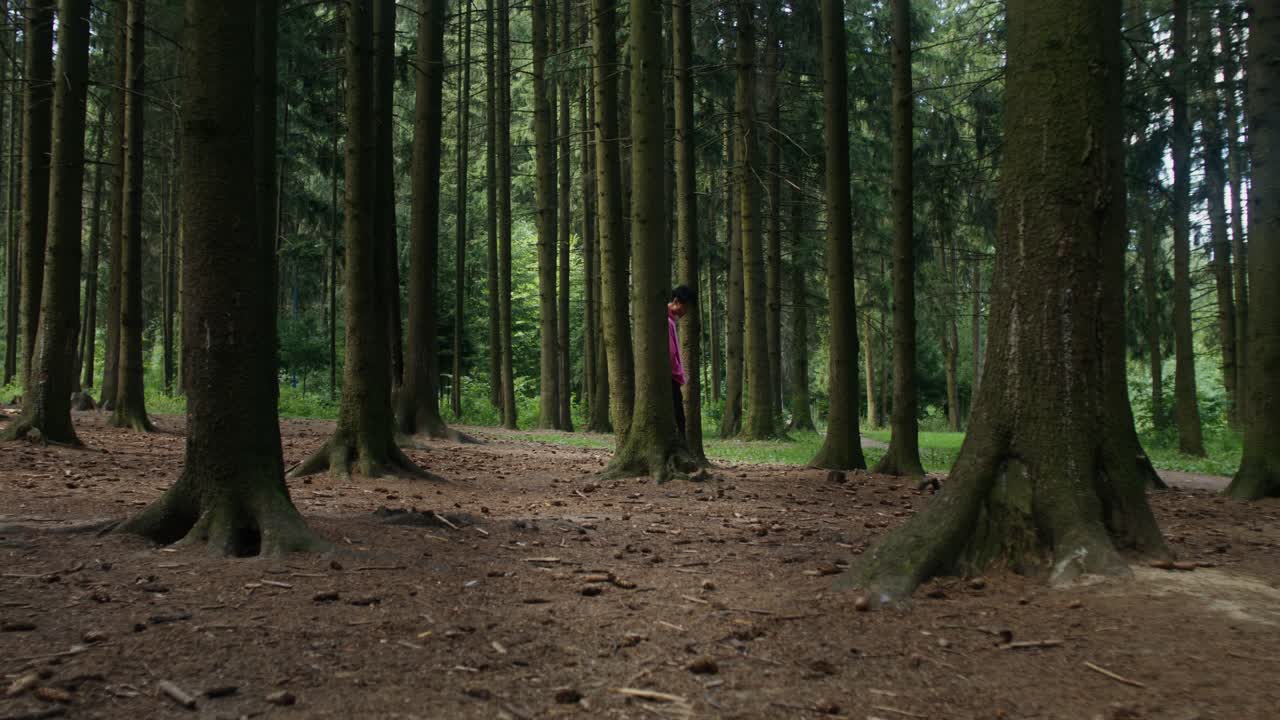 A person in a pink hoodie in the forest