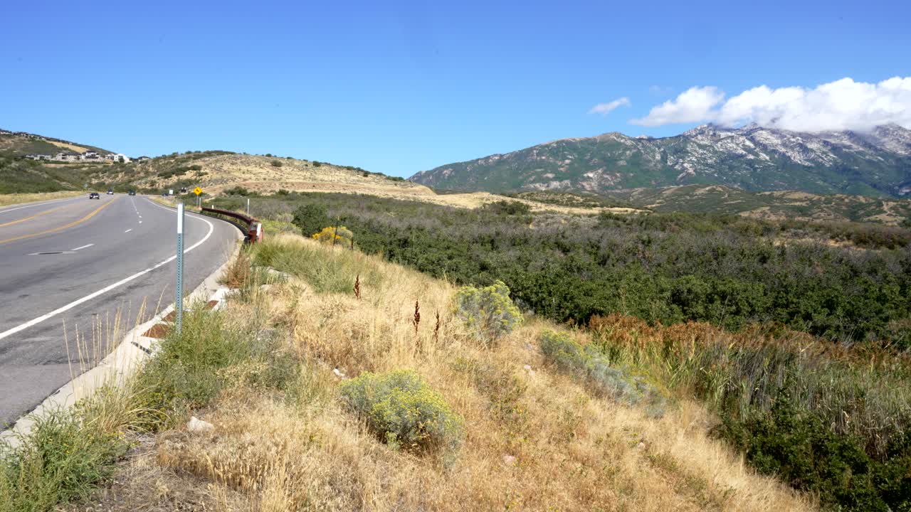 vista panorámica de las montañas rocosas y un camino sinuoso escuchar highland, utah en verano