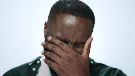 Portrait-of-smiling-african-guy-laughing-at-camera-on-light-background