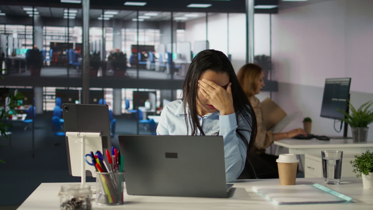 Stressed businesswoman in the office with a headache