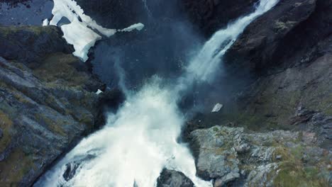 flying over the edge of spectacular vøringsfossen waterfall - closeup top-down aerial lokking down to waterfall - norway hardangervidda