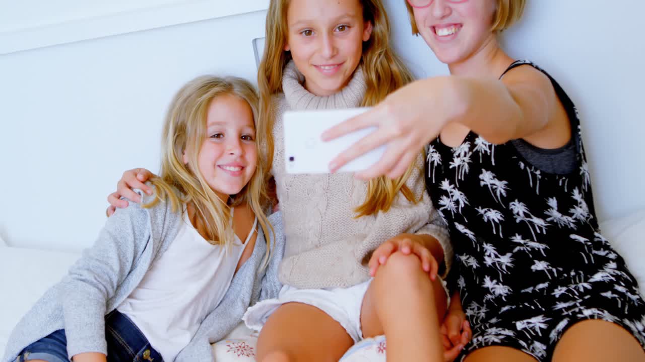 4k 침실에서 휴대폰으로 셀카를 찍는 형제자매