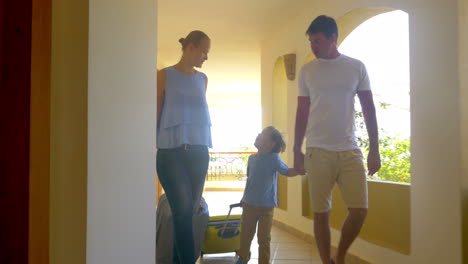 familia rodando bolsas de tranvía a lo largo del pasaje del hotel