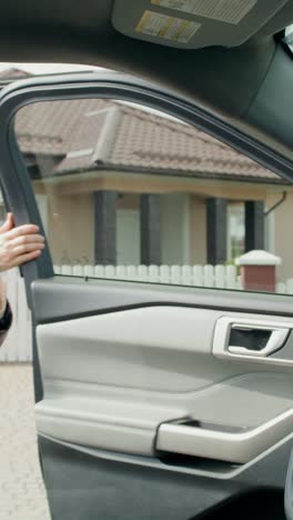 woman in car applying lipstick and checking phone