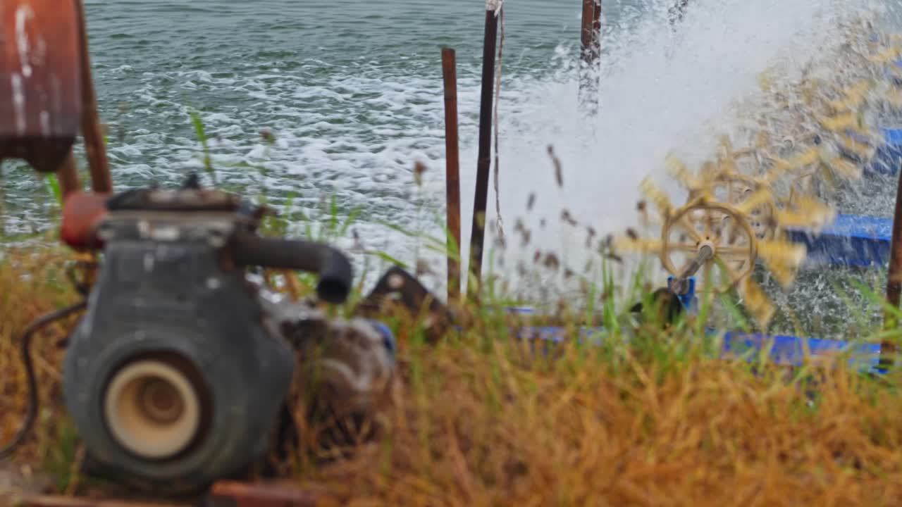 Aeratore meccanico a pale in funzione in uno stagno per acquacoltura per aumentare i livelli di ossigeno nell'acqua. Di giorno, leggera panoramica, 4k.