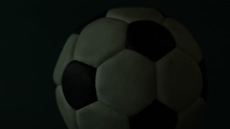 Toma-Cinematográfica-De-Un-Balón-De-Fútbol-Colocado-Sobre-Un-Fondo-Oscuro-Y-Sombrío.