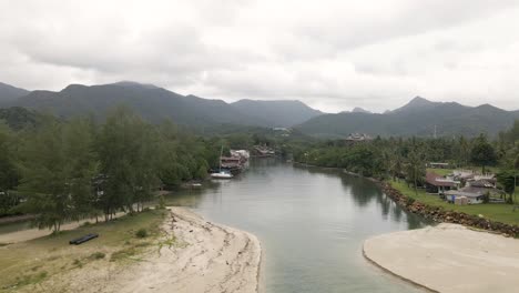 aerial view of river estuary and mountainous scenery, backwards and descending shot